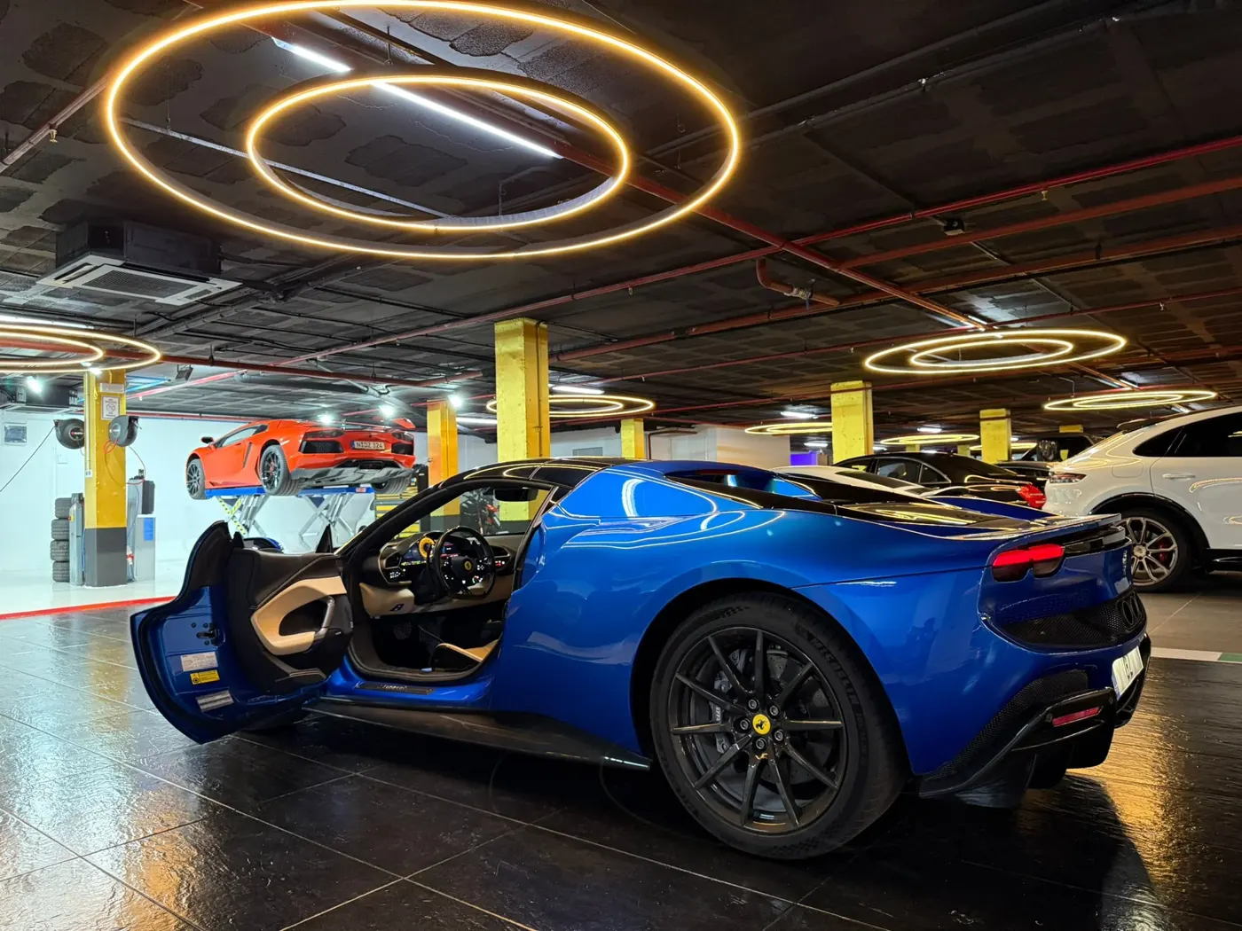 Auto’s onder ronde lampen in de garage van GT Race Marbella